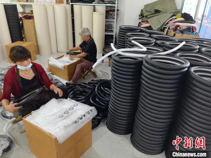 圖為村民在汽車飾品企業(yè)生產(chǎn)車間中工作?！巫雍?攝