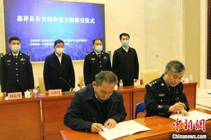 山東博物館館長鄭同修和嘉祥縣人民政府副縣長、公安局局長趙健簽署移交協(xié)議。　趙曉 攝