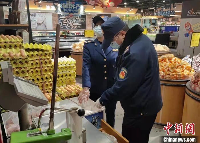 圖為疫情期間，甘肅嘉峪關(guān)市場監(jiān)管局工作人員檢查蔬菜市場?！?柴佳楠 　攝