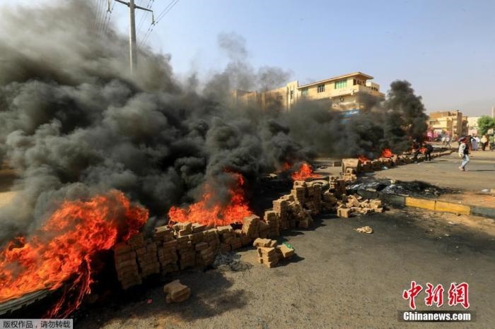 當(dāng)?shù)貢r(shí)間10月25日，蘇丹局勢(shì)發(fā)生突變，過(guò)渡政府總理被“綁架”，政府部長(zhǎng)被軍方抓捕，國(guó)家進(jìn)入緊急狀態(tài)，大量民眾走上街頭對(duì)軍方行動(dòng)進(jìn)行抗議，已有7人在抗議活動(dòng)中死亡，140人受傷。圖為抗議活動(dòng)中燃燒的輪胎。