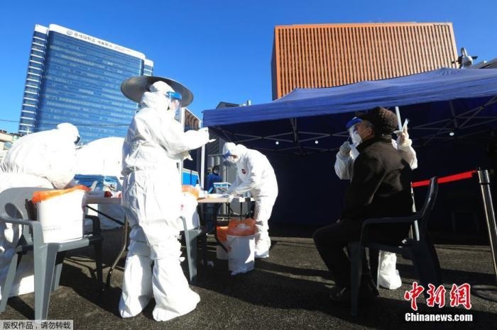 資料圖：韓國首爾，醫(yī)務(wù)人員對市民進行新冠病毒檢測。