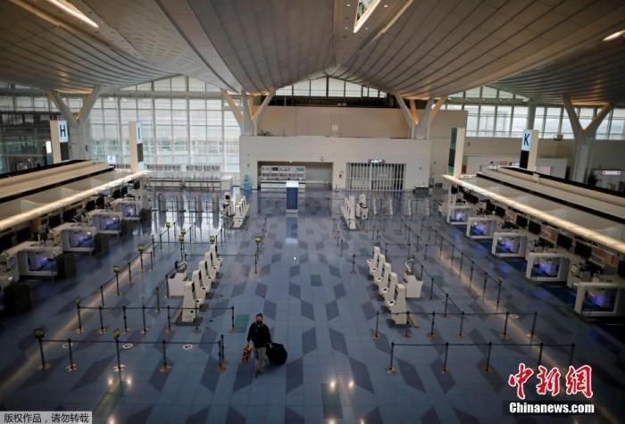 資料圖：日本東京，東京國際機(jī)場，一名乘客在國際航班航站樓的登機(jī)區(qū)。