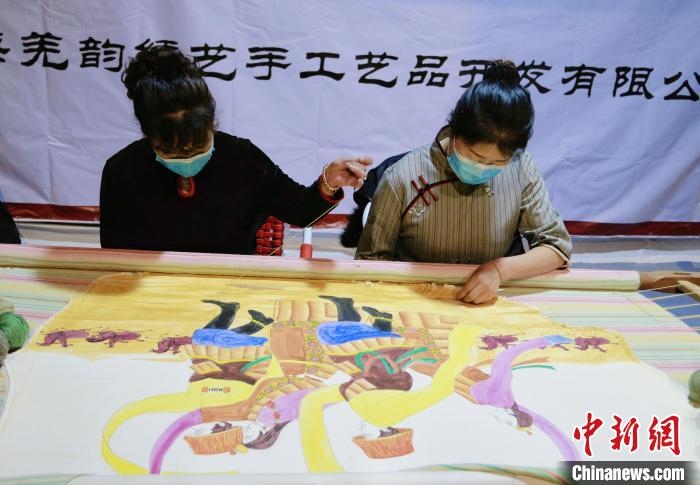 圖為皮繡藝人在市集上“秀”指尖技藝?！●R銘言 攝