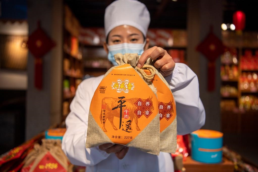 1月27日，在平遙古城南大街的一家平遙牛肉店內，工作人員展示一款牛肉產品。新華社記者 楊晨光 攝