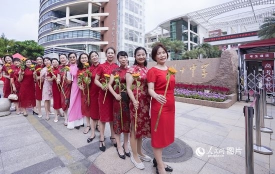 6月7日一早，廈門雙十中學(xué)考生家長(zhǎng)們身穿旗袍，手拿向日葵在考場(chǎng)外為孩子加油打氣，寓意“旗開(kāi)得勝，一舉奪魁”。人民網(wǎng)記者 陳博攝