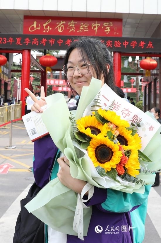 6月7日高考首日，山東67萬(wàn)考生走進(jìn)考場(chǎng)，拼搏逐夢(mèng)。在山東省實(shí)驗(yàn)中學(xué)考點(diǎn)，考生進(jìn)考場(chǎng)前手捧向日葵花拍照留念，寓意“一舉奪魁”。人民網(wǎng)記者 劉祺攝
