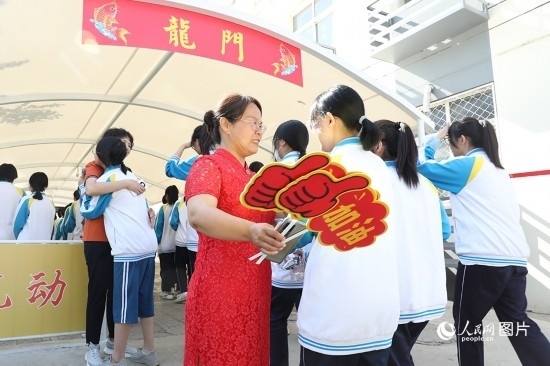 6月7日一早，雄安新區(qū)安新中學(xué)老師在給同學(xué)們加油鼓勁兒。人民網(wǎng) 李兆民攝
