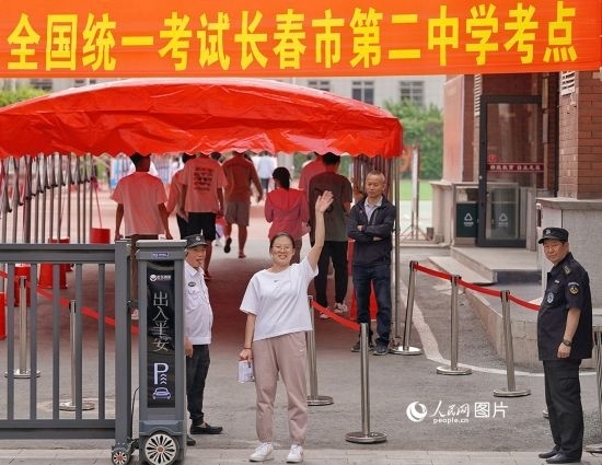 6月7日，在長(zhǎng)春市第二中學(xué)考點(diǎn)，一名考生信心滿滿進(jìn)入考場(chǎng)，并與家長(zhǎng)揮手致意。人民網(wǎng)記者 李洋攝