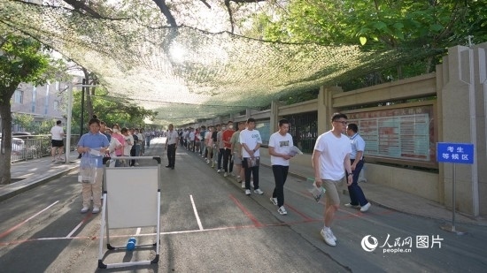 6月7日，烏魯木齊市第七十中學(xué)門口，考生們有序進(jìn)入考場(chǎng)。人民網(wǎng) 李欣洋攝