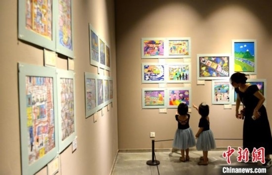 圖為家長(zhǎng)帶著孩子參觀展覽。呂明 攝