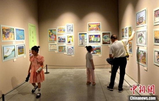 圖為家長(zhǎng)帶著孩子參觀展覽。呂明 攝