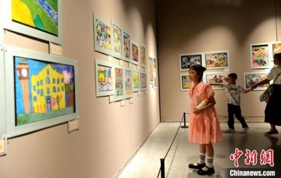 圖為家長(zhǎng)帶著孩子參觀展覽。呂明 攝