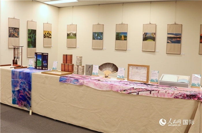 現(xiàn)場(chǎng)展出的馮學(xué)敏攝影作品與湖州市特色工藝品。（人民網(wǎng) 許可攝）