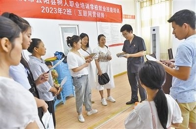  圖③：法院干警現(xiàn)場指導(dǎo)鄉(xiāng)村“代理家長”如何正確管護留守兒童。