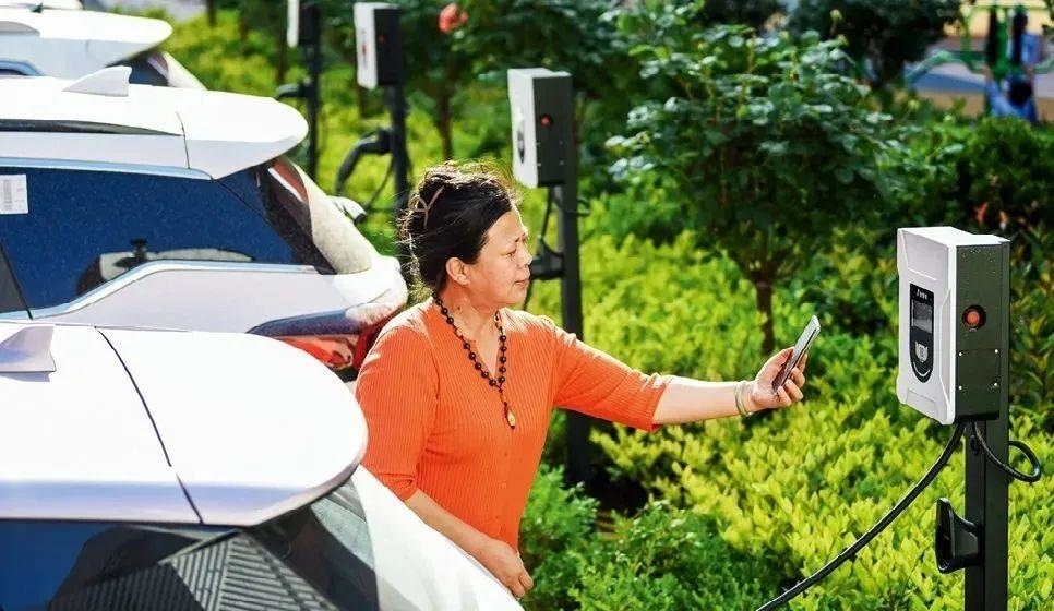 2023年5月24日，山東省膠州市新立街小區(qū)內一位居民使用電動汽車充電樁掃碼充電。該小區(qū)加裝各類智慧設備，打造“智慧社區(qū)”，為居民生活帶來便利。