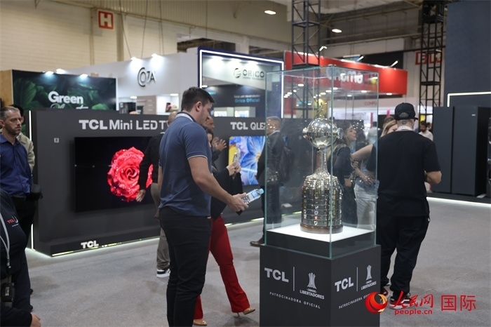 參觀者在TCL展臺前觀看南美解放者杯獎杯，據(jù)介紹，TCL是南美解放者杯（2023—2026賽季）全球官方合作伙伴。（人民網(wǎng)記者 時元皓攝）