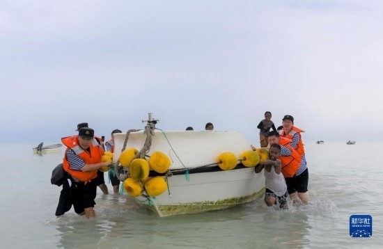 7月21日，中國(guó)海軍“和平方舟”號(hào)醫(yī)院船醫(yī)護(hù)人員涉水登島，前往基里巴斯一診療點(diǎn)。新華社記者 黎云 攝