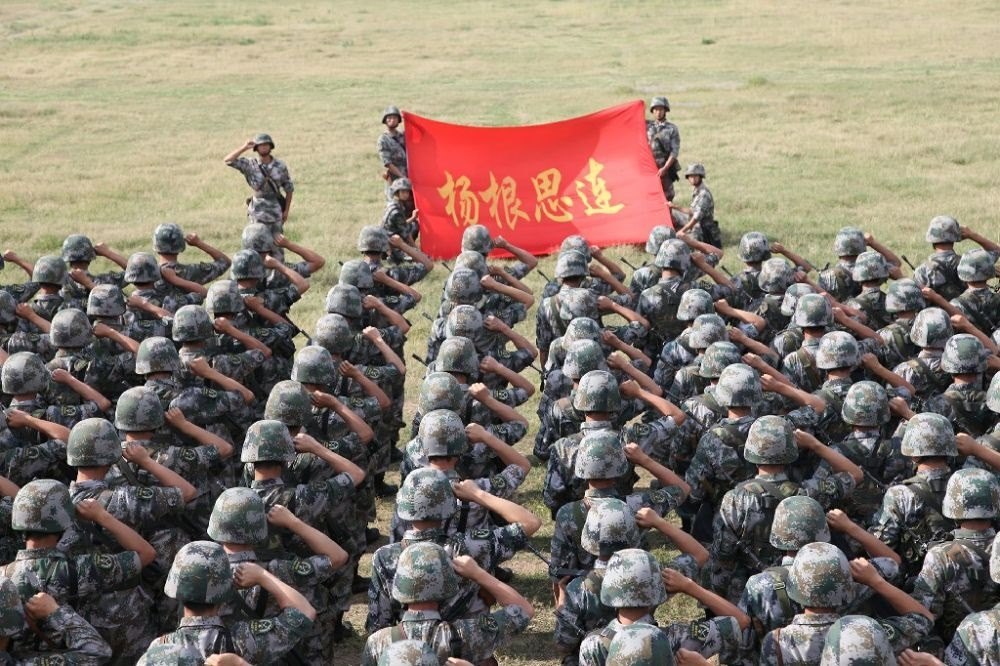↑“楊根思連”官兵執(zhí)行任務(wù)前向連旗宣誓（資料照片）。新華社發(fā)