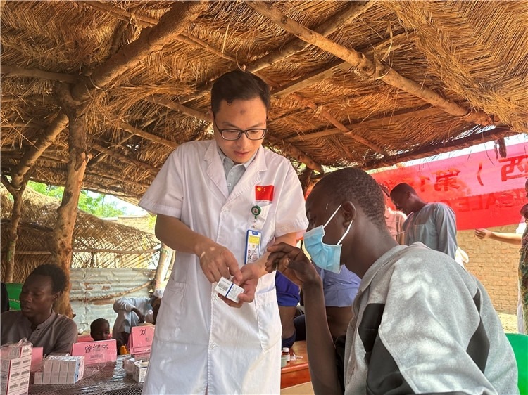 圖為南昌大學第一附屬醫(yī)院病理科主治醫(yī)師張振東為村民解說藥品使用方法。中國駐乍得醫(yī)療隊供圖