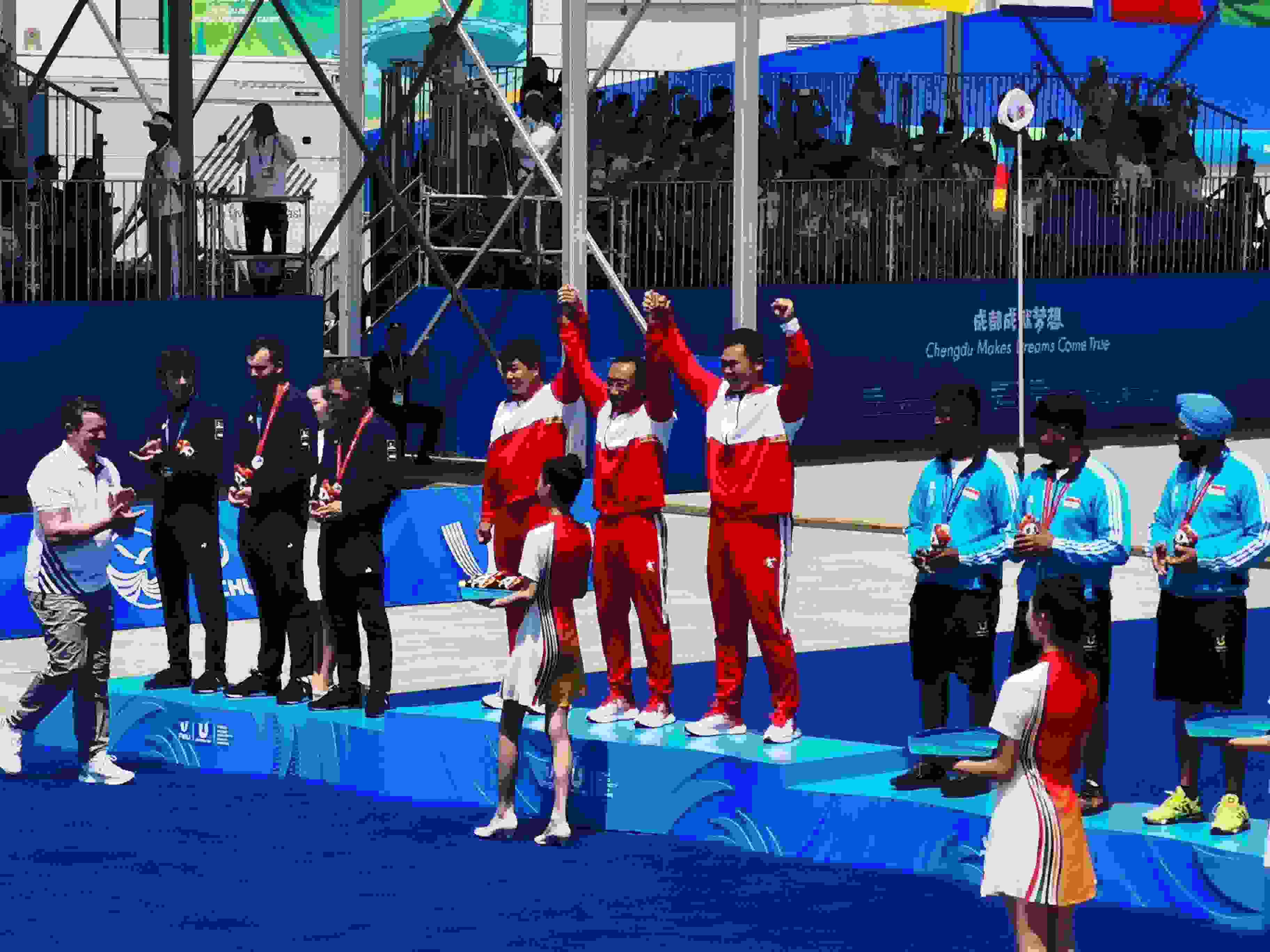 7月30日，在成都大運會男子復(fù)合弓團體頒獎儀式中，中國隊慶祝奪得冠軍。 人民網(wǎng)記者 楊磊攝