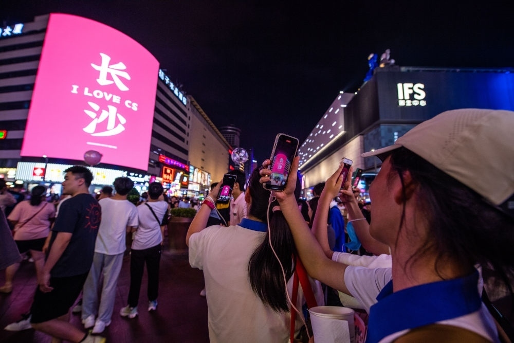  游客在長(zhǎng)沙市天心區(qū)黃興路步行街打卡、拍照（6月7日攝）。新華社記者 陳思汗 攝