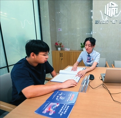 在杭州市臨安區(qū)政務(wù)服務(wù)中心的“為企服務(wù)中心”，黨員志愿者（右）解答企業(yè)主的疑問(wèn)（2023年7月7日攝）。徐昱攝/本刊