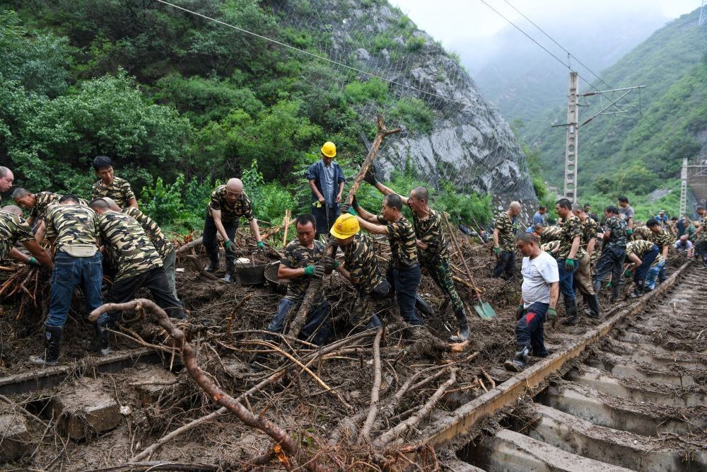 8月1日，在北京市門頭溝區(qū)水峪嘴村附近一段被阻斷的鐵路線上，中鐵六局工作人員在清理軌道上的雜物，全力恢復(fù)交通。新華社記者 鞠煥宗 攝