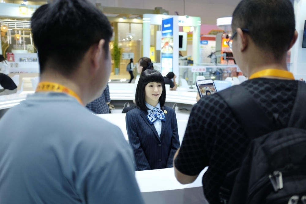 9月1日，媒體記者在國家會議中心與服務機器人互動。新華社記者 劉夢琪 攝