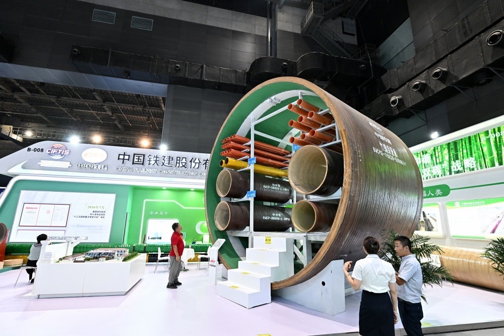 9月2日，在國(guó)家體育館舉行的服貿(mào)會(huì)環(huán)境服務(wù)專題展上，客商在中國(guó)鐵建展位竹纏繞管廊旁了解信息。新華社記者 李鑫 攝