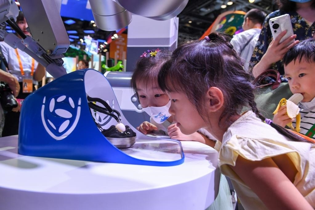 9月3日，幾名小朋友在國家會議中心觀看單孔腔鏡手術(shù)機器人展示。新華社記者 鞠煥宗 攝