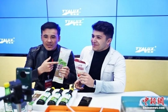 2023年3月，甘肅省慶陽市環(huán)縣電商創(chuàng)業(yè)孵化基地內(nèi)，來自蘭州文理學院的塔吉克斯坦留學生正在協(xié)助主播直播帶貨當?shù)剞r(nóng)特產(chǎn)品。李亞龍 攝