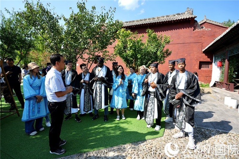 圖為選手們聽導(dǎo)游講解。人民網(wǎng) 盧鵬宇攝