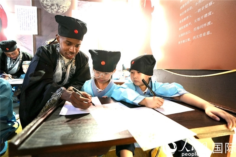 圖為選手與同學(xué)們一起寫書法。人民網(wǎng) 盧鵬宇攝