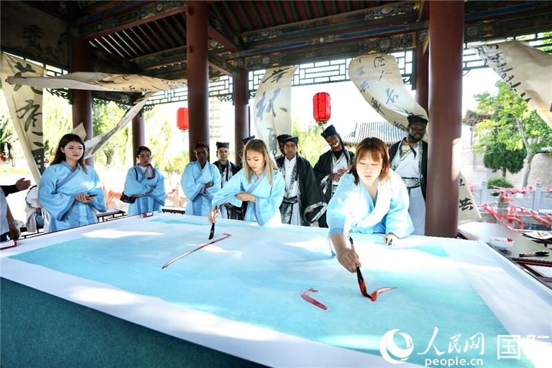 選手們提筆書寫“家園”二字。人民網(wǎng) 盧鵬宇攝