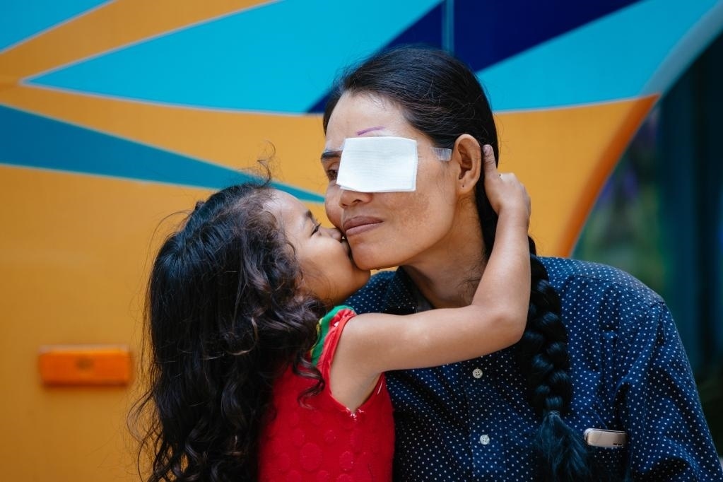 2019年3月15日，在柬埔寨磅湛省醫(yī)院，即將接受白內(nèi)障手術(shù)的患者孫美樂(lè)接受女兒的親吻祝福。在接受了中國(guó)醫(yī)療隊(duì)的白內(nèi)障義診手術(shù)后，她的視力逐步恢復(fù)，生活有了新的光明和希望。