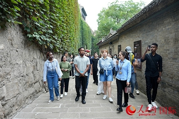 選手們認(rèn)真聆聽導(dǎo)游講解。人民網(wǎng) 盧鵬宇攝