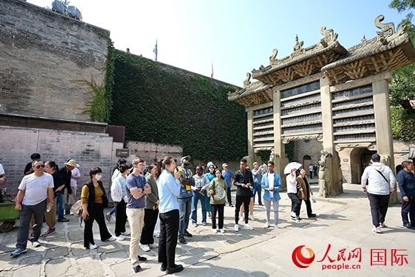 選手們認(rèn)真聆聽導(dǎo)游講解。人民網(wǎng) 盧鵬宇攝