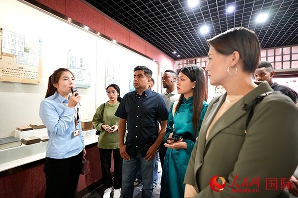 選手們認(rèn)真聆聽導(dǎo)游講解。人民網(wǎng) 盧鵬宇攝