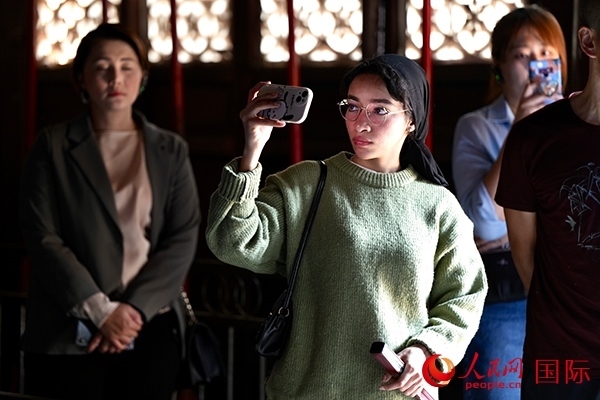 選手顏青（蘇丹）用手機(jī)記錄所見所感。人民網(wǎng) 盧鵬宇攝