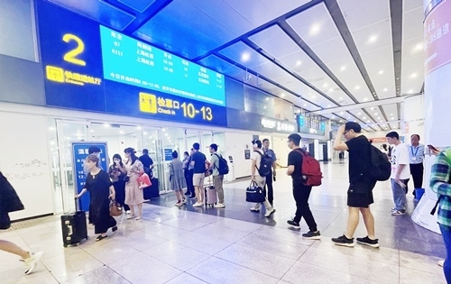 在快速進(jìn)站廳前排隊(duì)等待檢票的旅客。人民網(wǎng)記者 喬雪峰攝