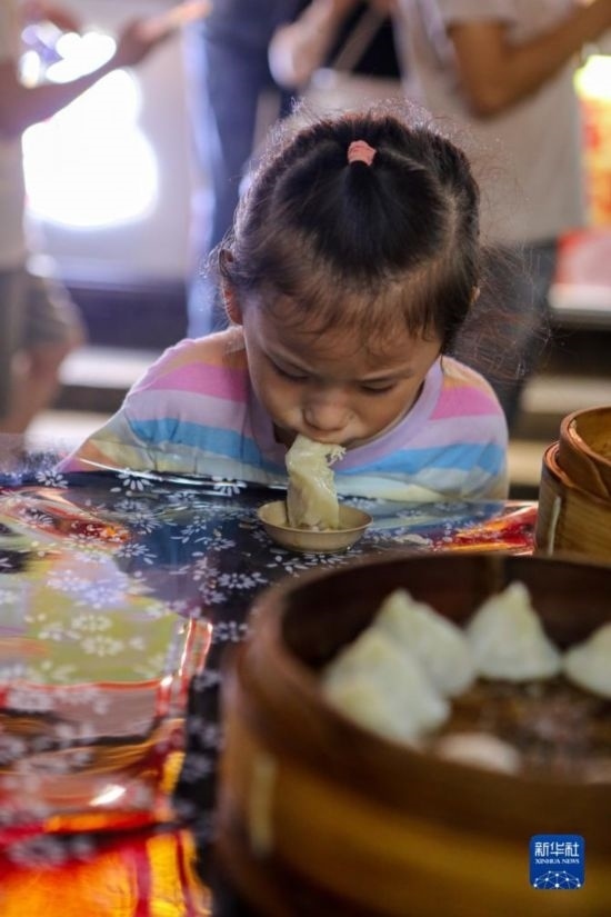 9月27日，小朋友在南翔小籠長街宴上品嘗南翔小籠。