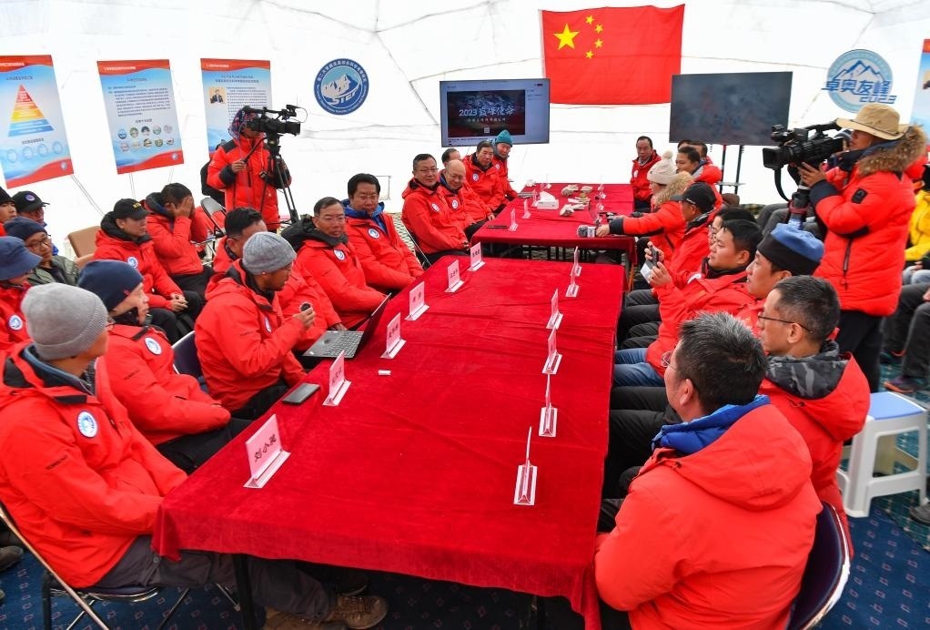 海拔4950米的卓奧友峰科考大本營，科考隊(duì)員趙華標(biāo)（手拿麥克風(fēng)看電腦者）在宣讀剛剛接收到的頂峰氣象觀測數(shù)據(jù)，這標(biāo)志著峰頂自動氣象站架設(shè)成功，成功傳回觀測數(shù)據(jù)（10月1日攝）。新華社記者晉美多吉 攝