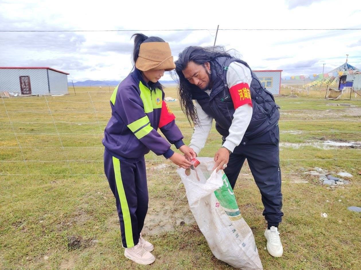 玉樹州稱多縣珍秦鎮(zhèn)河湖志愿者才培和他女兒更求拉毛在清掃垃圾。受訪者供圖