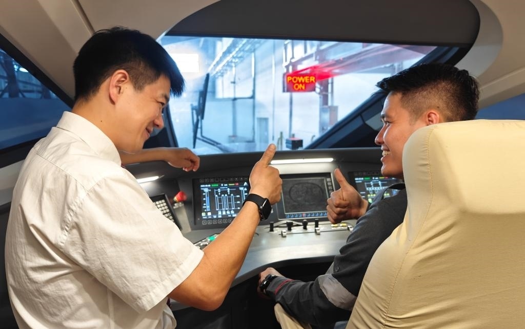 8月25日，在印度尼西亞萬隆的雅萬高鐵德卡魯爾動(dòng)車所內(nèi)，中國師傅穆振（左）在向印尼火車司機(jī)塞蒂亞萬講解動(dòng)車組出庫前的上電作業(yè)。