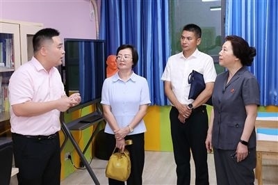 圖③：“小公民法律課堂”開(kāi)講前，全國(guó)人大代表殷其龍（右二）、重慶市人大代表李自玲（左二）聽(tīng)取楊家坪中學(xué)負(fù)責(zé)人關(guān)于未成年人思想教育工作情況的介紹。