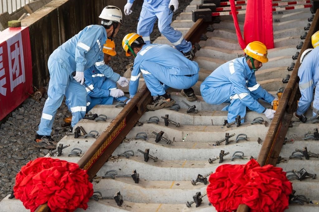 3月31日，在印度尼西亞雅加達(dá)雅萬高鐵哈利姆車站，工人鋪設(shè)雅萬高鐵全線最后一根鋼軌。