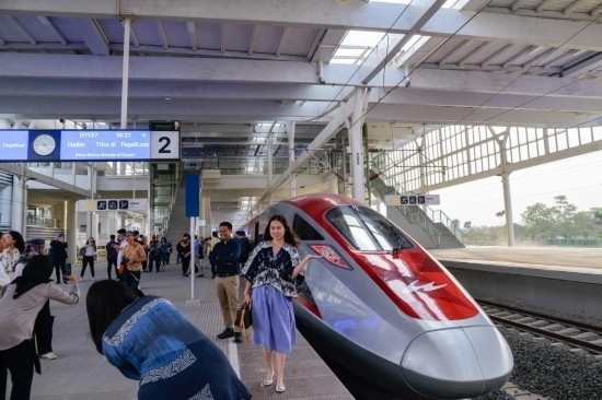  10月17日，在印度尼西亞萬隆德卡魯爾站，乘客在站臺(tái)上和雅萬高鐵高速動(dòng)車組列車合影。新華社記者 徐欽 攝