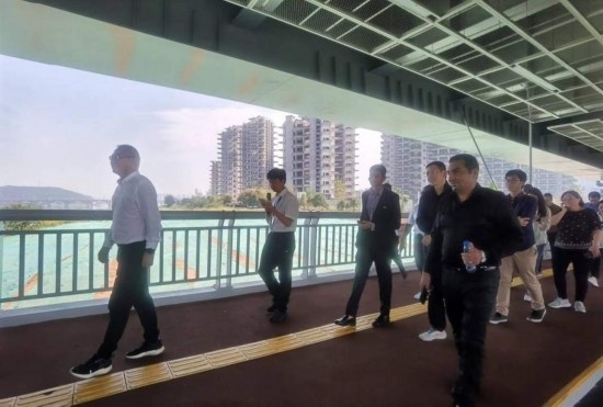 10月24日，2023“一帶一路”媒體合作論壇聯(lián)合采訪團(tuán)團(tuán)員走在清水塘大橋景觀通道上。本報(bào)記者 常雯宜攝