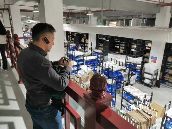 2023“一帶一路”媒體合作論壇聯(lián)合采訪團(tuán)團(tuán)員在仁和醫(yī)藥物流園拍攝記錄轉(zhuǎn)運(yùn)流程。（本報(bào)記者 黃超攝）