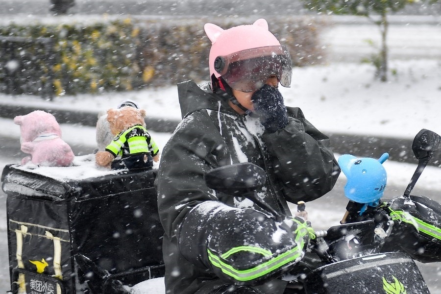 11月6日，在長春市街頭，一名外賣員在雪中騎行。新華社記者 許暢 攝